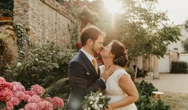Les mariés se font photographier à la golden hour dans le jardin familial en Normandie